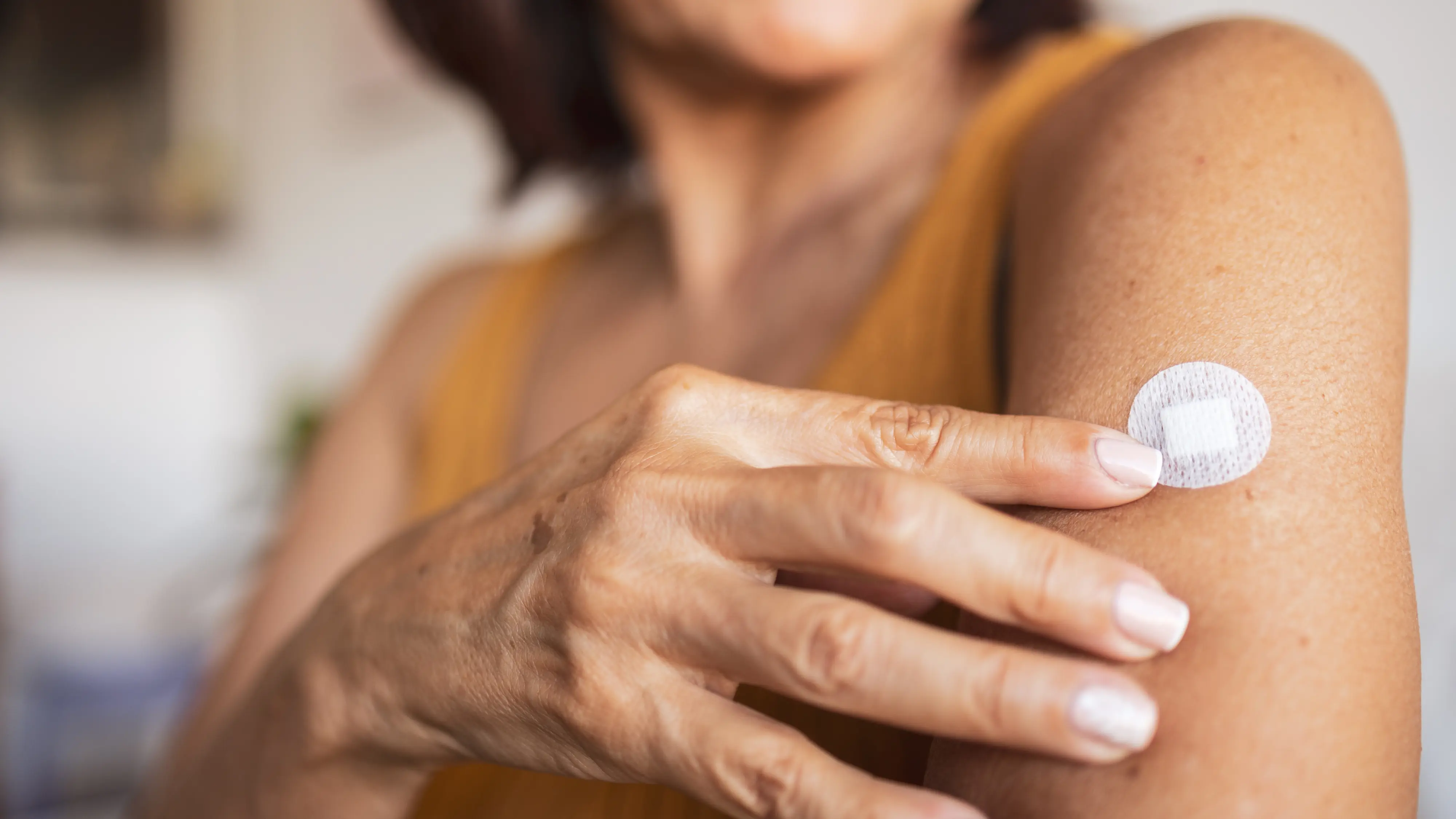Patient with a bandage on the upper arm after a vitamin shot